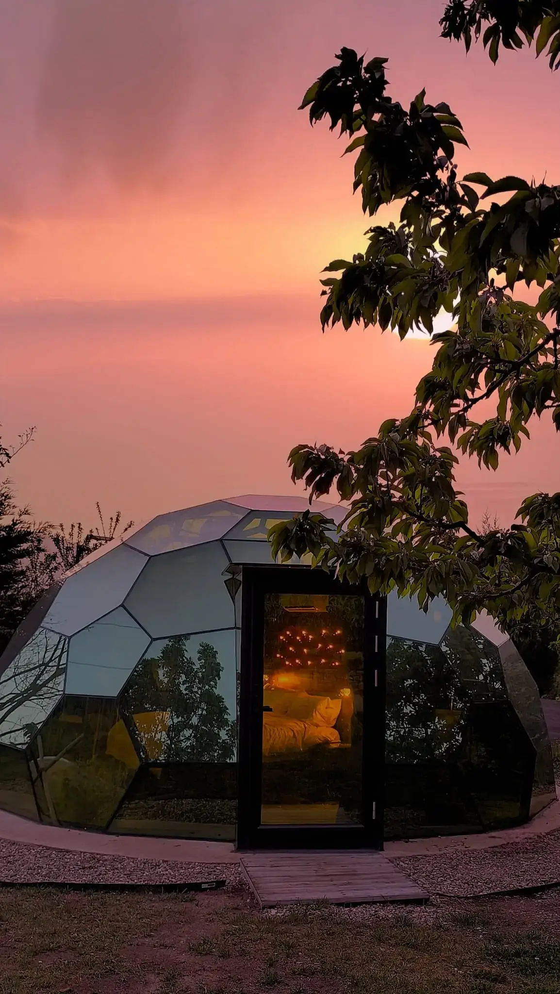 El Sky Dome iluminado al atardecer, con el cielo naranja detrás